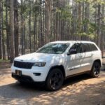 White Jeep Grand Cherokee parked in a campsite at Canyon Campground in Yellowstone National Park