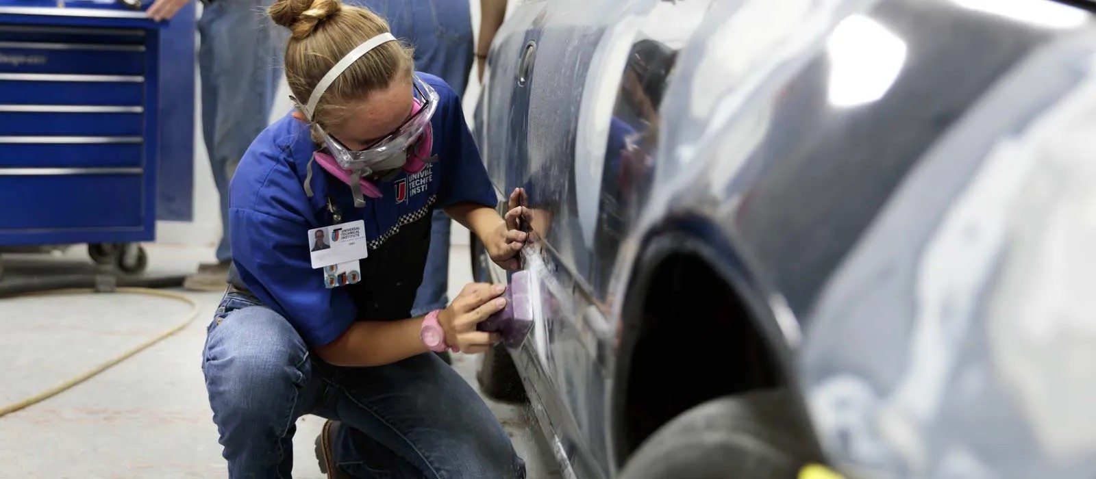 Professional auto body technician using a wrench to dismantle a car part