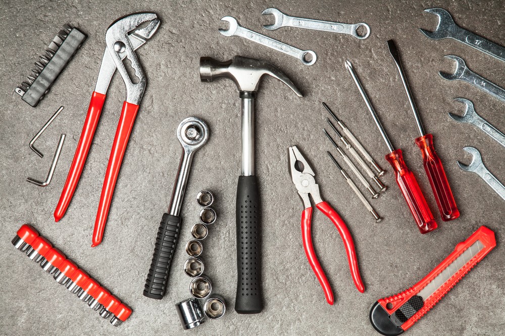 Essential Tool Kit for Car: Tools laid out including sockets, wrenches, screwdrivers, pliers, and a jack.