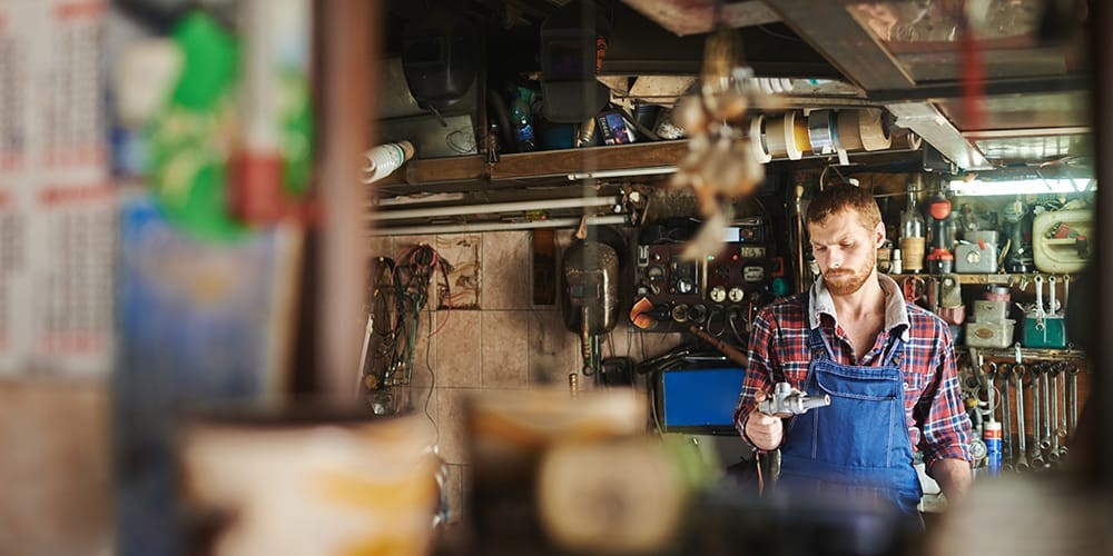 Mechanic inspecting a car engine with tools