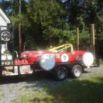 alt text: An open car trailer with a toolbox at the front.