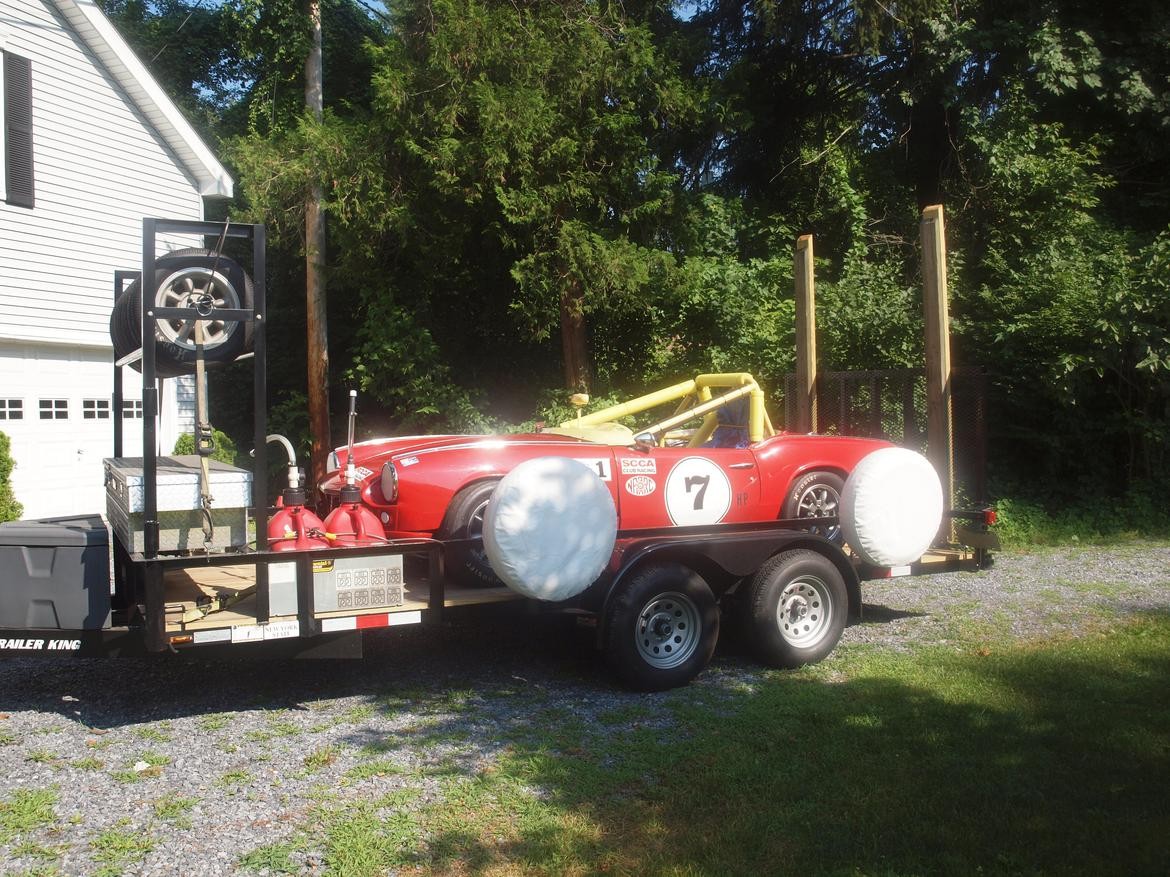 alt text: An open car trailer with a toolbox at the front.