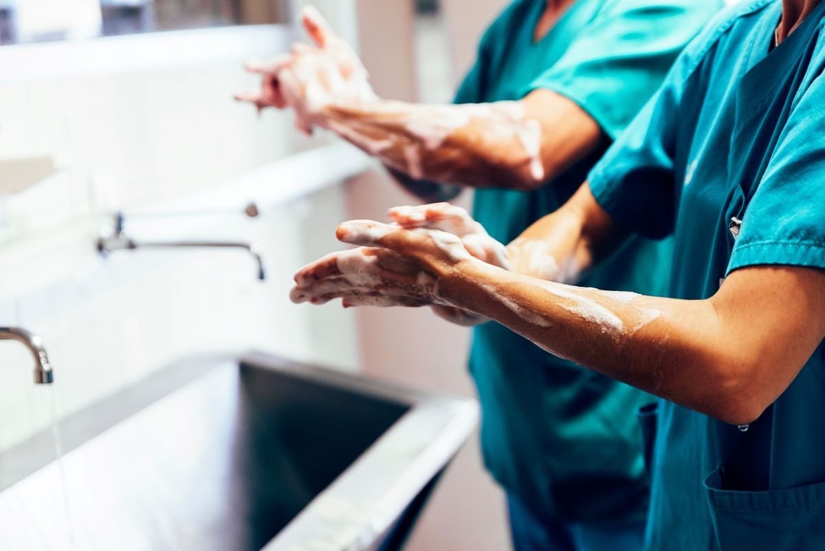 A nurse demonstrates proper hand hygiene by washing her hands.